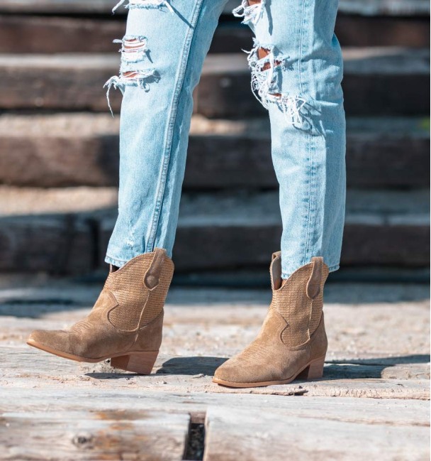 Beige cowboy style boots with woven shaft and medium heel.