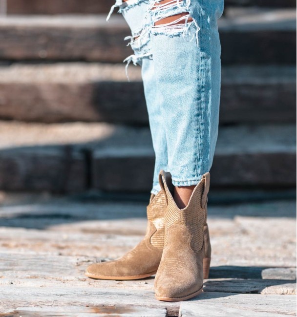 Beige cowboy style boots with woven shaft and medium heel.