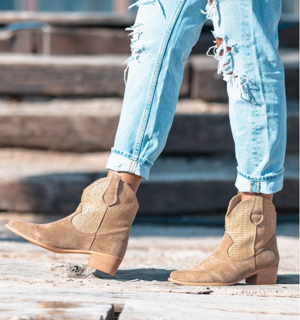 Beige cowboy style boots with woven shaft and medium heel.