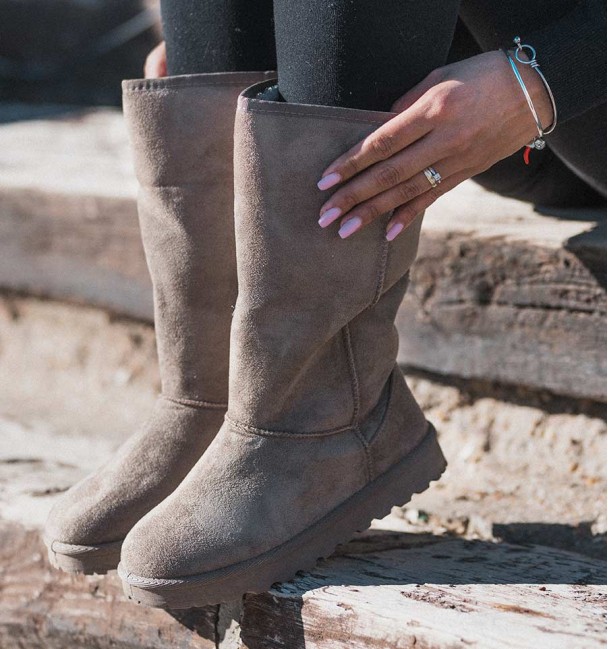 Botas altas australianas em cor caqui, planas, com costura e pelo no interior. Material têxtil semelhante, camurça.