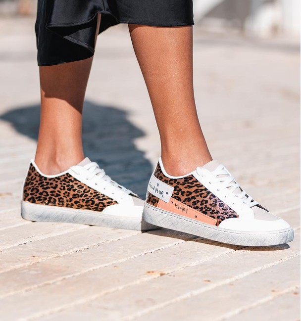white sneakers with leopard print and side phrase detail. Vegan leather