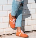 Orange sports shoes with side stripe and pink laces. Brown rubber sole. Animal free