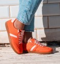 zapatillas deportivas naranjas con raya lateral y cordones rosa. Suela goma marrón. Animal free