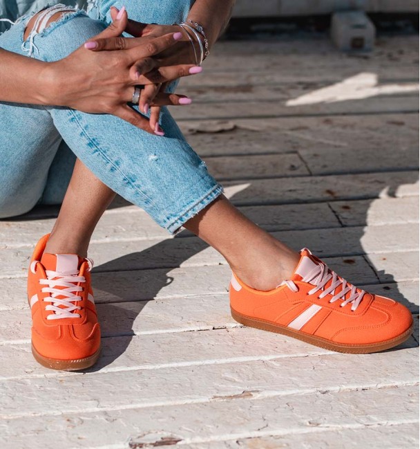 zapatillas deportivas naranjas con raya lateral y cordones rosa. Suela goma marrón. Animal free