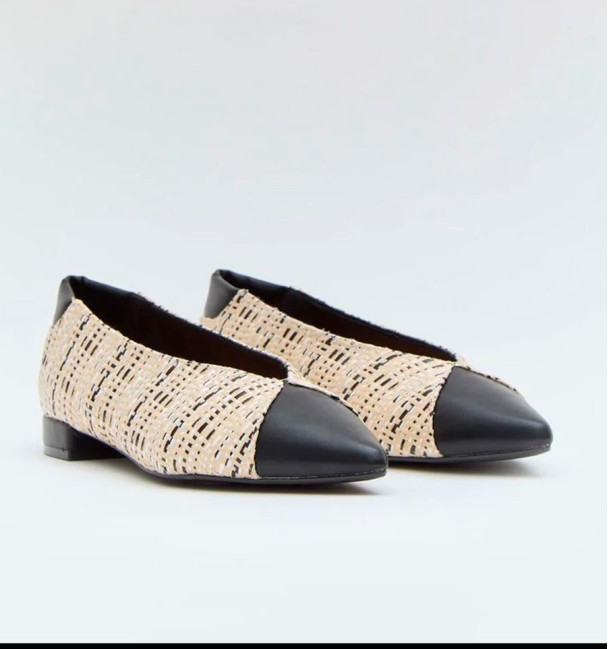 zapatos planos jaspeados blancos y negros con puntera y tacón negros.